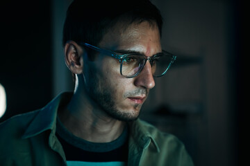 Caucasian web developer and IT support specialist coding in dark office, working on cybersecurity, hacking prevention and cloud computing.