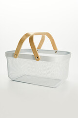 an iron basket with wooden handles on a white background