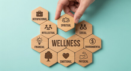 Hand placing wooden hexagon with spiritual icon on wellness concept with occupational, intellectual, physical, emotional and social aspects
