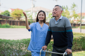 Obraz premium Senior man in wheelchair enjoying outdoor time with family and caregiver nurse, symbolizing elderly care, support, healthcare, nursing service, and happy retirement life.