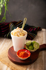 Esquites. Corn kernels cooked and served with mayo, sour cream, lemon and chili powder, very popular street food in Mexico, also known as Elote en Vaso. The recipe varies depending on the region.