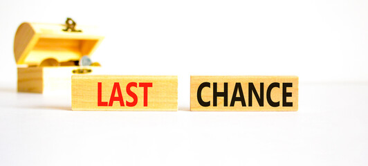 Last chance symbol. Concept word Last chance on beautiful wooden blocks. Beautiful white paper background. Beautiful wooden chest with coins. Business last chance concept. Copy space.
