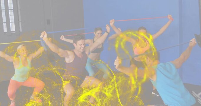 Coach cueing overhead band pull, fitness group squatting while yellow overlay swirling around limbs