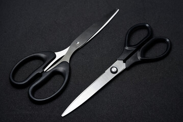Two scissors on a black background. Stationery scissors.