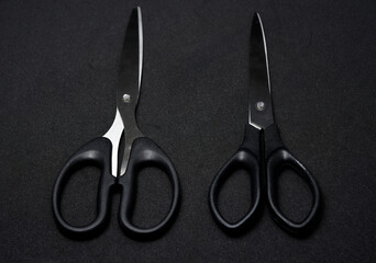 Two scissors on a black background. Stationery scissors.