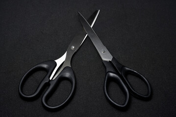 Two scissors on a black background. Stationery scissors.