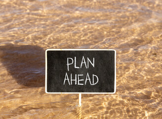 Naklejka premium Plan ahead symbol. Concept word Plan ahead on beautiful black blackboard. Beautiful Red sea water background. Black blackboard. Business plan ahead concept. Copy space.
