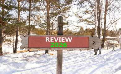 Review 2026 symbol. Concept words Review 2026 on beautiful wooden road sign. Beautiful winter forest background. Business and review 2026 concept. Copy space.