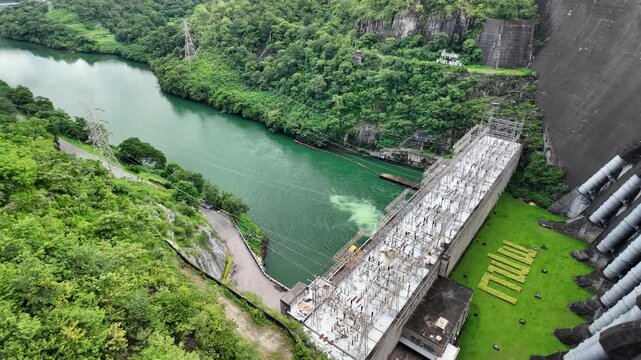 Bhumibol Dam, Thailand, beautiful scenery amidst the nature of river near large dam, with mountains and trees. Renewable hydropower plants for generating electricity reduce greenhouse gas emissions.