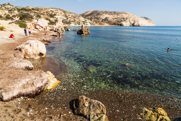 Paphos, Cyprus - 10 November 2023: Tourists swimming in the sea near Aphrodite’s rock, a birthplace of Aphrodite