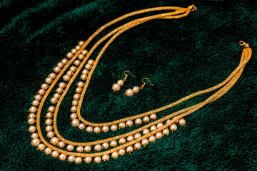 Elegant Pearl Necklace and Earring Set on Green Velvet. Elegant Layered Necklace Set with Red and White Beads. necklace and earrings