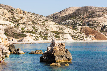 Paphos, Cyprus - 10 November 2023: Small toddler playing in the water near Aphrodite’s rock is a sea stack in Paphos, Cyprus. A birthplace of Aphrodite