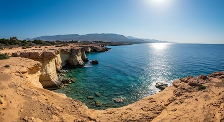 Coastal landscape with sea cliffs under clear blue sky and bright sunlight