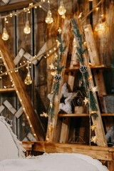 Decorated Christmas interior with glowing light bulbs and garland with evergreen pine branches and cones. Holiday decoration and festive mood.