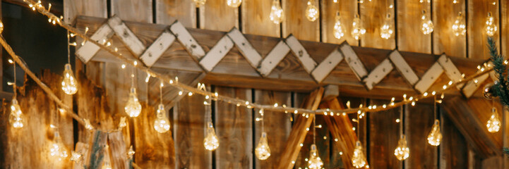 Blurred warm Christmas lights creating a festive bokeh effect against a wooden background. Holiday decoration concept for seasonal celebration.