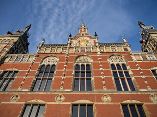 Amsterdam, Netherlands; February-24, 2025: View of the beautiful facade of Amsterdam Central Station (Netherlands) at sunset