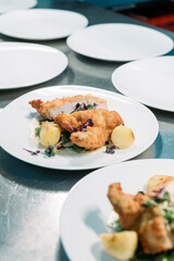 Knuspriges Hähnchenbrustfilet mit Kartoffeln, Gemüse und Sauce, elegant serviert auf gedecktem Tisch