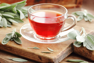 Clary sage  tea in glass cup with fresh leaves on wooden rusric table, closeup,natural green medicine concept