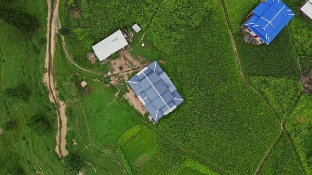 Aerial View of Arang Kel, Azad Kashmir &mdash; Scenic Mountain Village with Colorful Houses, Lush Greenery, and Misty Hills Surrounded by Dense Pine Forests on a Cloudy Day