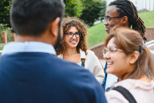 Diverse university students talking outdoors, sharing ideas