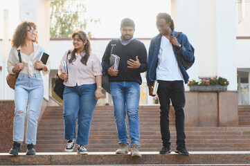 Obraz premium Diverse students walking down university stairs together
