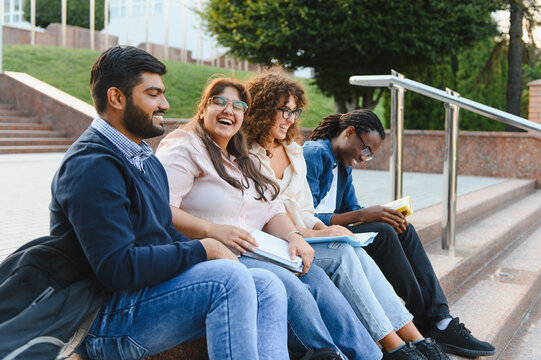 Diverse students studying together on campus stairs
