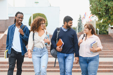 Obraz premium Diverse university students walking on campus stairs