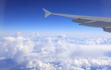 airplane in flight from which a wing and the clouds from high up are seen ideal as a concept of travel