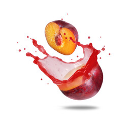 Plum cut in half with splashes of juice on a white background