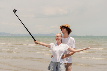 Happy young couple enjoying playful piggyback ride at the beach during sunset. Perfect for concepts like romance, summer vacation, freedom, fun, and relationship lifestyle imagery.