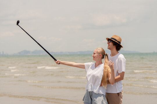 Happy young couple enjoying playful piggyback ride at the beach during sunset. Perfect for concepts like romance, summer vacation, freedom, fun, and relationship lifestyle imagery.