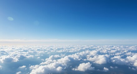 Aerial view of fluffy white clouds against a bright blue sky background