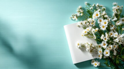 An elegant book lies peacefully beside a fresh floral arrangement on a soothing turquoise background, symbolizing tranquility, introspection, and a passion for reading.