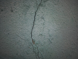 Obraz premium Close-up of a cracked old green wall with peeling paint and rough texture, ideal for backgrounds, design elements, or projects needing vintage rustic surfaces.