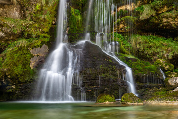 Obraz premium Long exposure of beautiful cascading Virje Waterfall in green nature, Slovenia, Europe