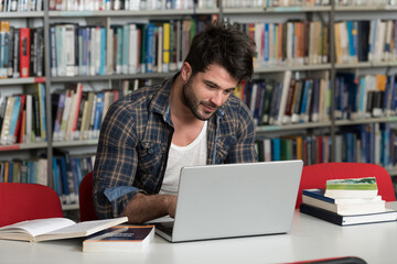 Student Using His Laptop in a Library
