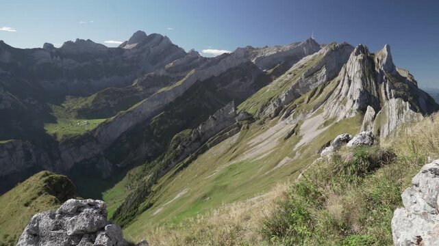 Altenalpt&uuml;rme limestone towers from Sch&auml;fler ridge, steep grass slopes under clear blue summer sky with S&auml;ntis vista; ideal for adventure travel and outdoor brands.