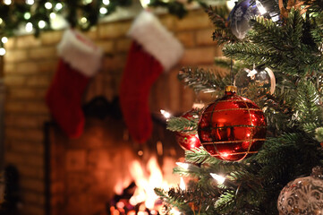 A Christmas tree with fireplace and stockings in background