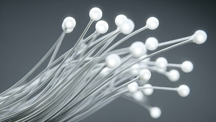 White spheres atop wispy lines against grey backdrop