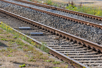 Obraz premium Journey awaits on parallel train tracks stretching into the distance under bright sunlight