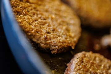 Juicy burger patties sizzling in a pan creating mouthwatering deliciousness for your next meal