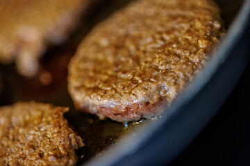 Juicy burger patties sizzling in a hot pan, creating mouthwatering culinary deliciousness