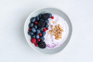 Berry yogurt bowl with granola and more fresh berries topping, isolated superfood bowl
