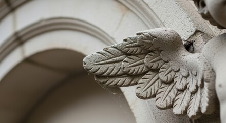 Close-up of ornate stone angel wing sculpture on arched building facade