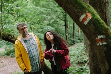Father daughter looking at forest trail markers