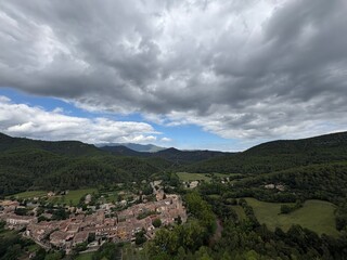 Beautiful small village on a valley rural scene on a cloudscape in Girona