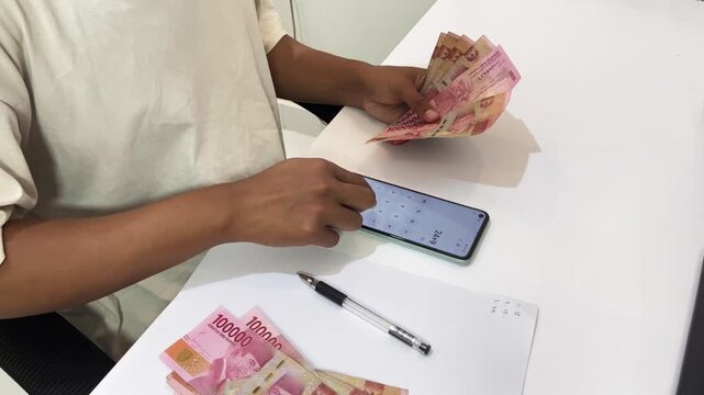 Calculate business financial turnover in a note and calculator on a smartphone.