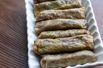 Close-Up of Turkish-Style Cabbage Rolls on a Square Plate on a Brown Table	