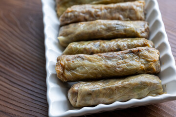 Close-Up of Turkish-Style Cabbage Rolls on a Square Plate on a Brown Table
