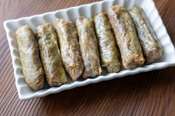 Close-Up of Turkish-Style Cabbage Rolls on a Square Plate on a Brown Table